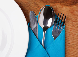 Knife, Fork, Spoon and plate on wooden table.