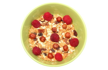 Heap of muesli with hazelnut and raspberries in green bowl