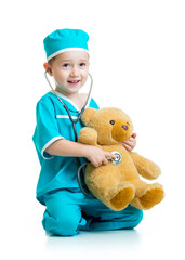 Adorable child with clothes of doctor examining  bear toy