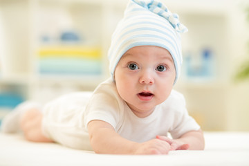 baby boy lying on bed in nursery