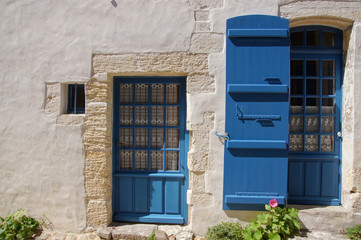 Fototapeta na wymiar Façade de maison blanche à volet bleu de Talmont-sur-Gironde