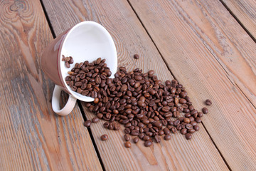 Cup with coffee beans on a wooden table