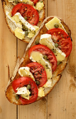Bruschetta with tomatoes, brie cheese and capers
