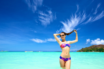 Beautiful young female in bikini on tropical beach