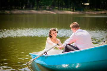 Fototapeta na wymiar beautiful newlyweds in wedding day in a boat
