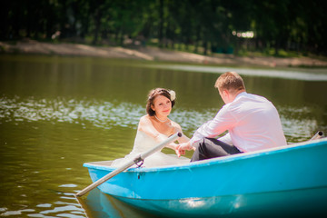 Fototapeta na wymiar beautiful newlyweds in wedding day in a boat