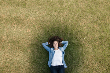 One young girl lying on the grass - view from top - filtered ima