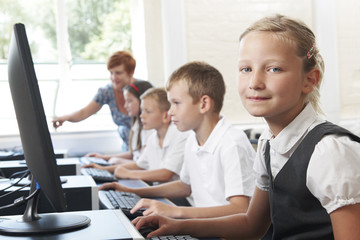 Group Of Elementary Pupils In Computer Class With Teacher