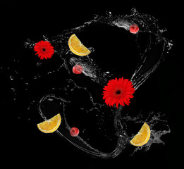 Obraz na płótnie Canvas Fresh fruits and flowers in water splash, on black background