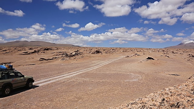 Car driving through the desert in the Altiplano, Bolivia