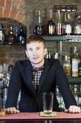 young man working as a bartender in a nightclub bar