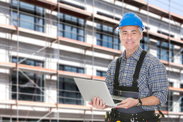Architect Using Laptop Against Building