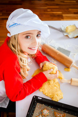 Mädchen backt in der Küche Weihnachtsplättchen
