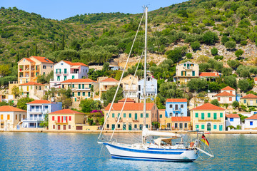 Yacht on sea and colorful houses of Vathi town, Ithaka island