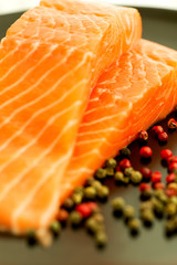 Raw salmon ready to cook close up on black surface