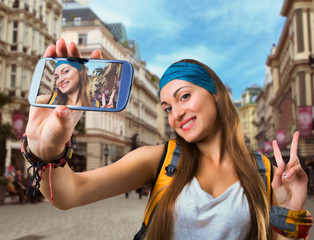 Happy traveler woman is taking selfie