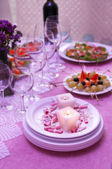 Buffet table with dishware and candles waiting for guests