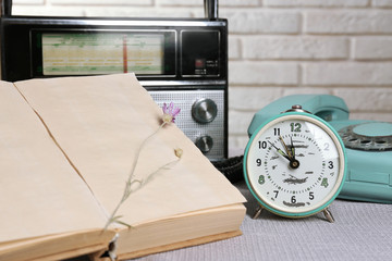 Naklejka premium Retro composition with old phone, radio, clock and books, close