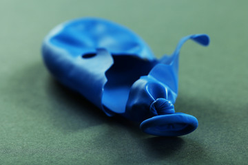 Popped blue balloon on paper background