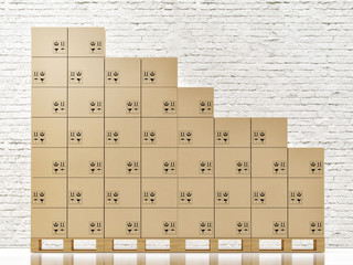 Cardbord boxes on wooden pallete in front of white brick wall