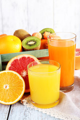 Fruit and vegetable juice in glasses and fresh fruits in box