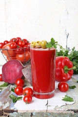 Glass of tomato juice and fresh vegetables