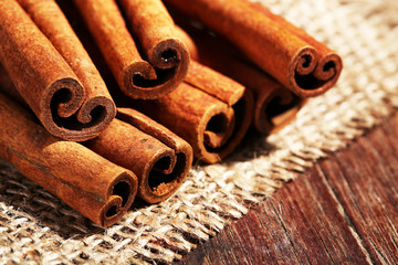 Cinnamon sticks on sackcloth on table close up
