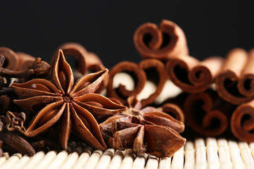 Carnation with cinnamon sticks and star anise on dark