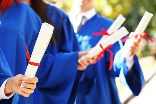 Graduate students with diplomas, close-up