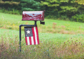 Roadside Mailbox with Antique Flag found in Country setting.