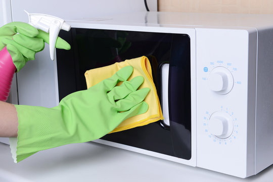 Cleaning microwave oven in kitchen close-up