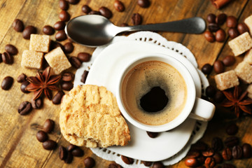 Cup of coffee and tasty cookie on wooden background
