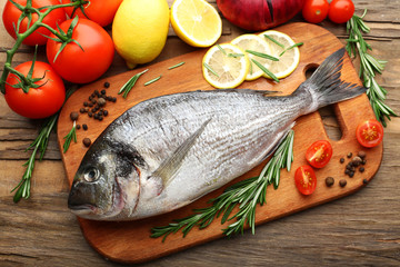 Fresh raw fish and food ingredients on table