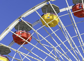 Colorful Ferris Wheel in amusement park with blue sky