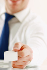 Portrait of young handsome business man holding blank white