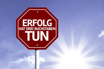 Success Has To Do Three Letters (In German) written on red road