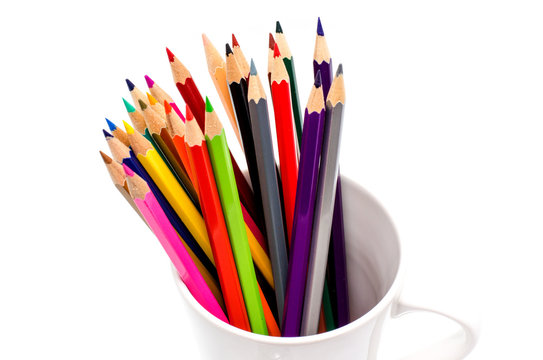 Stack of colored pencils in a glass on white background