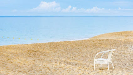 An empty chair on a sandy beach near the sea