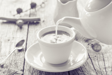 Fototapeta na wymiar pouring milk from jug cup black coffee