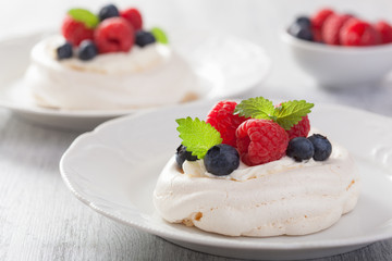 pavlova meringue cake with cream and berry