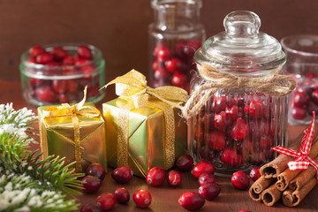 Obraz na płótnie Canvas fresh cranberry in glass jars, winter decoration and gifts