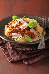 italian pasta spaghetti bolognese with basil on rustic table