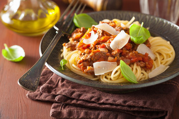 italian pasta spaghetti bolognese with basil on rustic table