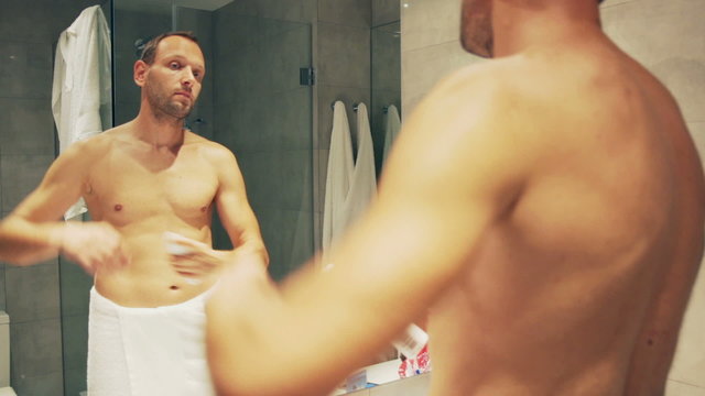 Man using antiperspirant and spraying it under arm