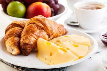 Croissants with cheese, fruits and coffee