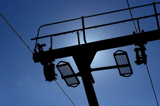 Ski lift from below with backlight of the sun