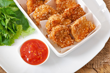 Chicken nuggets coated in cereals, crumbs and sesame