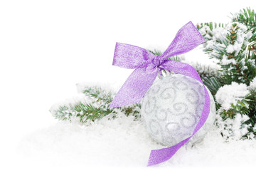 Fototapeta na wymiar Christmas bauble and purple ribbon with snow fir tree