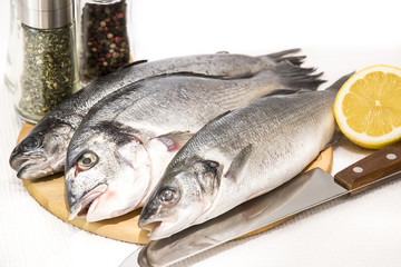 raw fish on a cutting board and knife