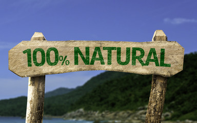 100% Natural wooden sign with a beach on background